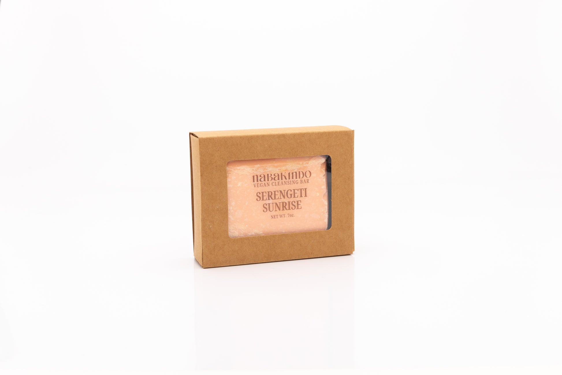 Photo of a peach colored, vegan, facial and body cleansing bar shown in sustainable packaging.