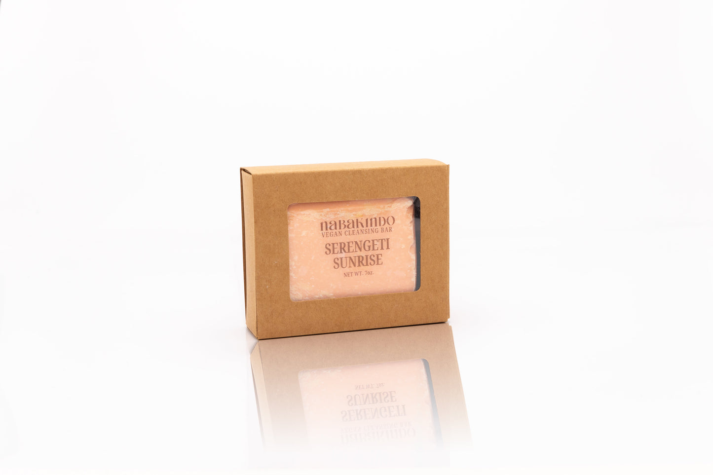 Photo of a peach colored, vegan, facial and body cleansing bar shown in sustainable packaging.